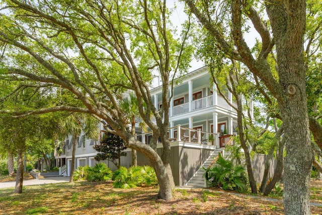 view of front facade with stairway, a balcony, and a porch