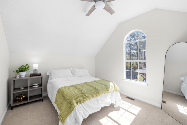 bedroom with a ceiling fan, visible vents, baseboards, lofted ceiling, and light carpet