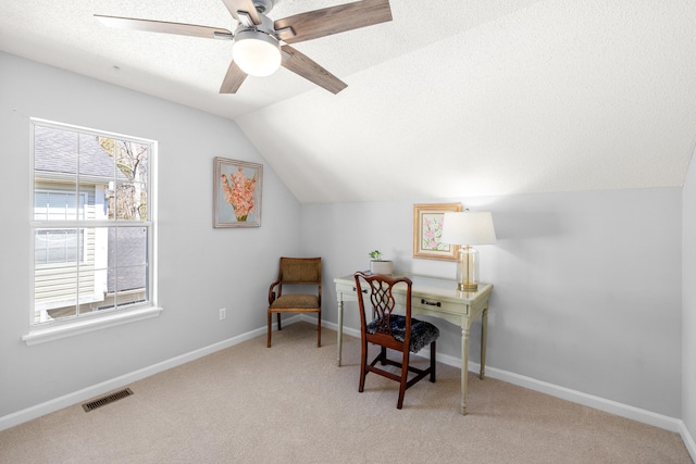 home office with visible vents, light carpet, ceiling fan, a textured ceiling, and vaulted ceiling