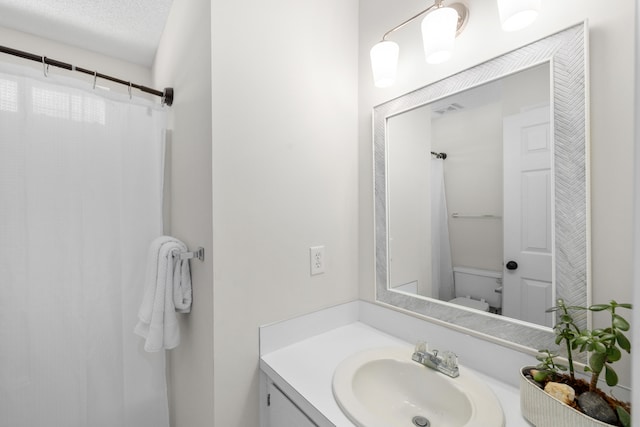 full bath featuring toilet, a shower with curtain, visible vents, and vanity