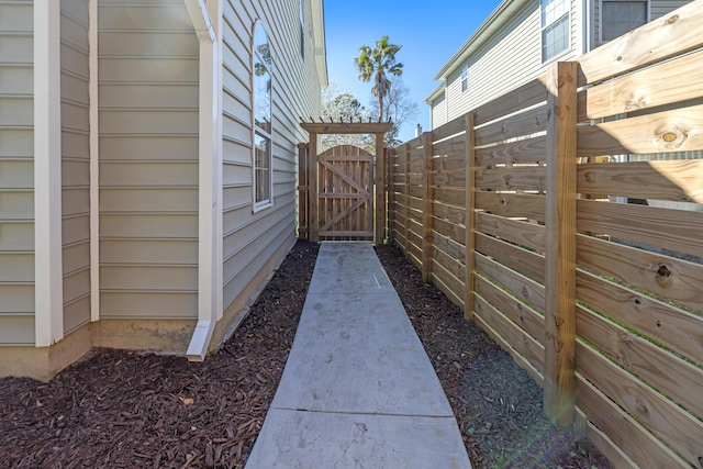 view of property exterior with fence and a gate