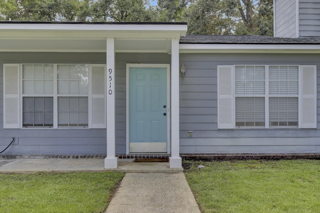 view of exterior entry with a lawn