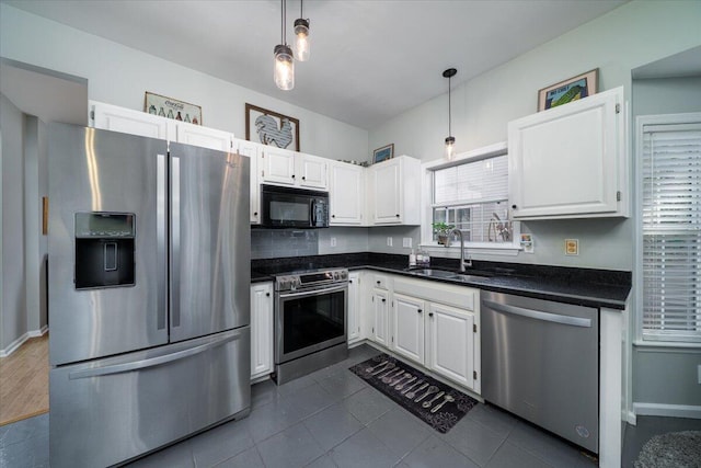 kitchen with a sink, dark countertops, white cabinetry, and stainless steel appliances