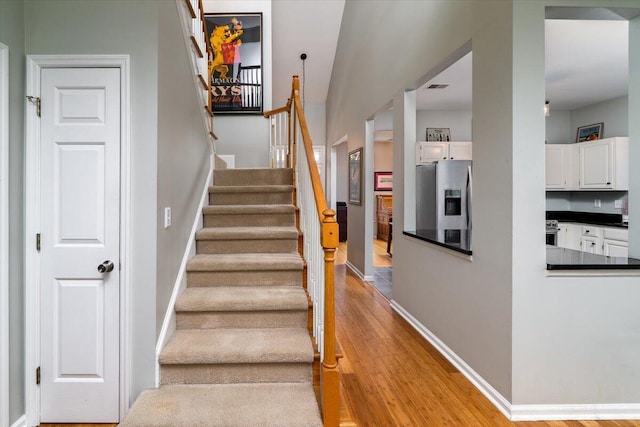 stairs featuring visible vents, baseboards, and wood finished floors