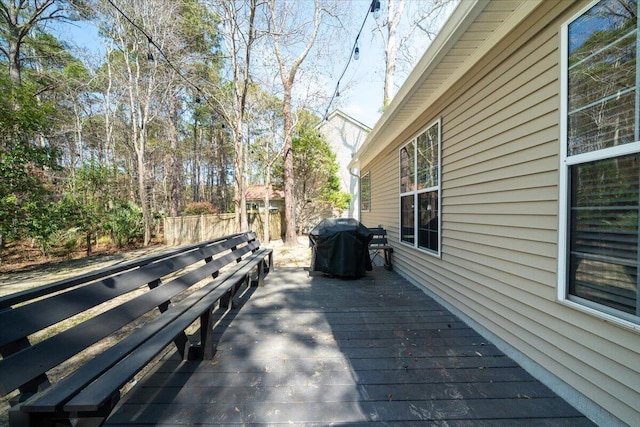 wooden deck with area for grilling and fence