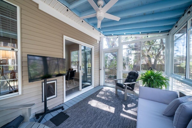 sunroom featuring beamed ceiling and ceiling fan