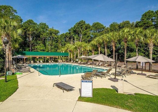 pool with a patio and fence