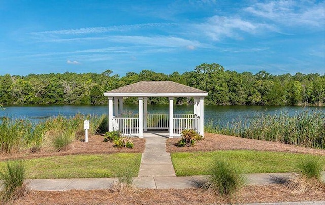 view of dock featuring a gazebo, a forest view, and a water view