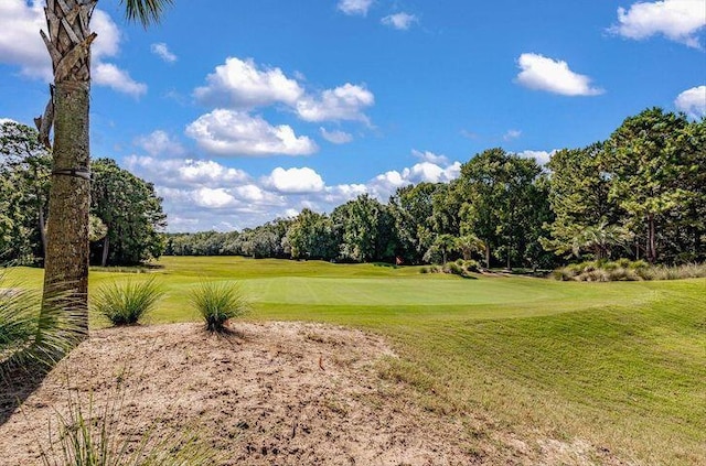 view of property's community featuring a yard and view of golf course