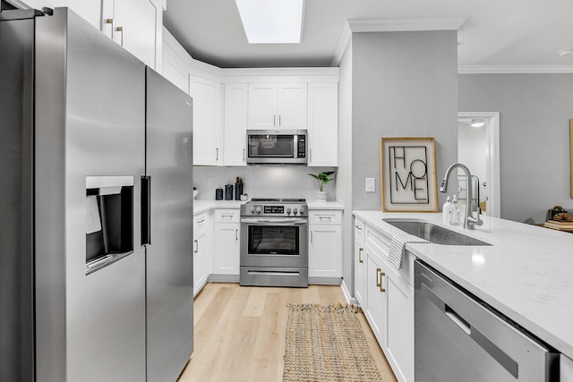 60 Fenwick Hall Aly Unit 415, Johns Island, SC 29455 - kitchen with stainless steel appliances, a sink, ornamental molding, light wood-style flooring, and decorative backsplash