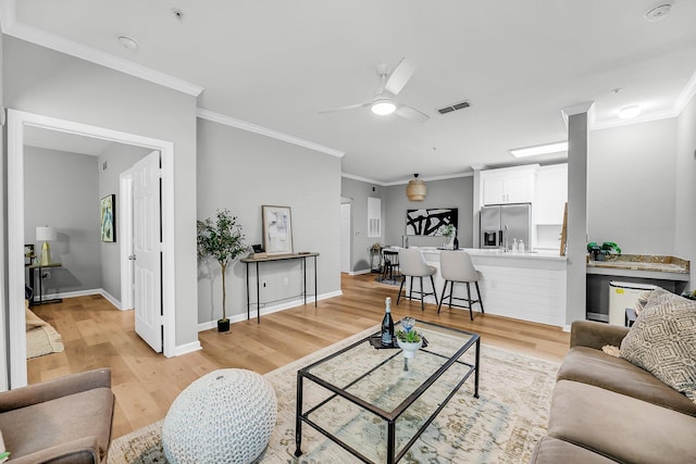 60 Fenwick Hall Aly Unit 415, Johns Island, SC 29455 - living room featuring light wood finished floors, ceiling fan, ornamental molding, and baseboards