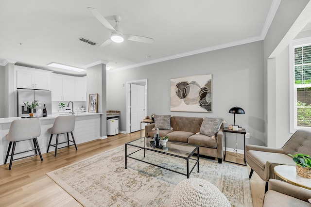 60 Fenwick Hall Aly Unit 415, Johns Island, SC 29455 - living room with light wood finished floors, ornamental molding, ceiling fan, and baseboards