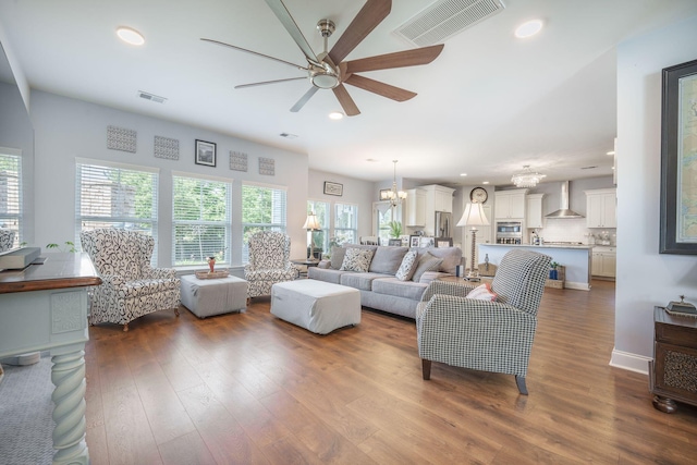 living room with a ceiling fan, wood finished floors, recessed lighting, and a chandelier