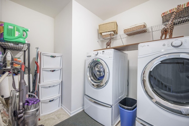washroom featuring separate washer and dryer, baseboards, and light tile patterned floors
