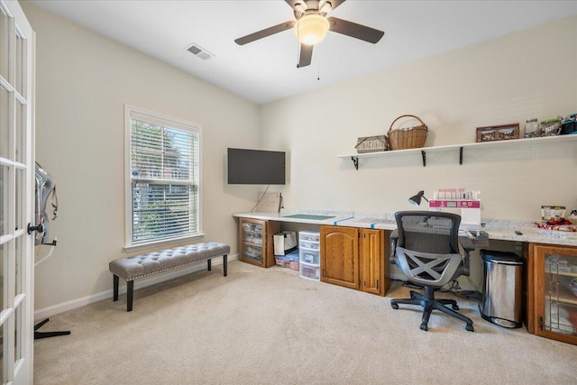 home office with baseboards, visible vents, a ceiling fan, and light colored carpet