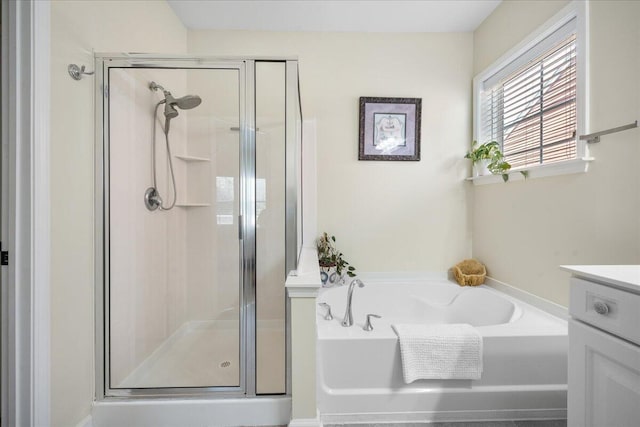 bathroom with a stall shower, vanity, and a bath