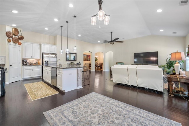 kitchen with arched walkways, lofted ceiling, visible vents, appliances with stainless steel finishes, and open floor plan