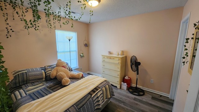 bedroom with dark hardwood / wood-style flooring and a textured ceiling