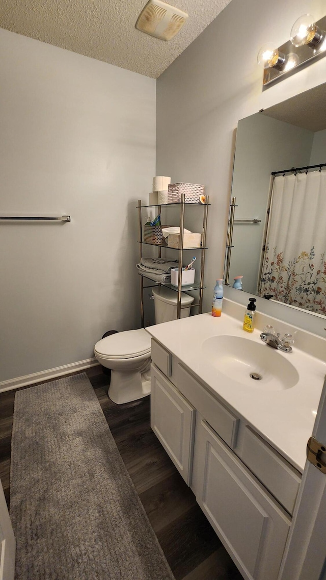 bathroom featuring toilet, vanity, a textured ceiling, and hardwood / wood-style flooring