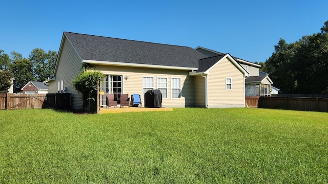 back of house with a lawn and a patio