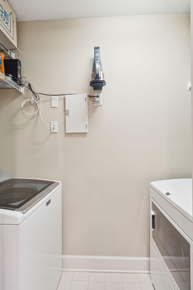 laundry room featuring laundry area, independent washer and dryer, baseboards, and light tile patterned floors