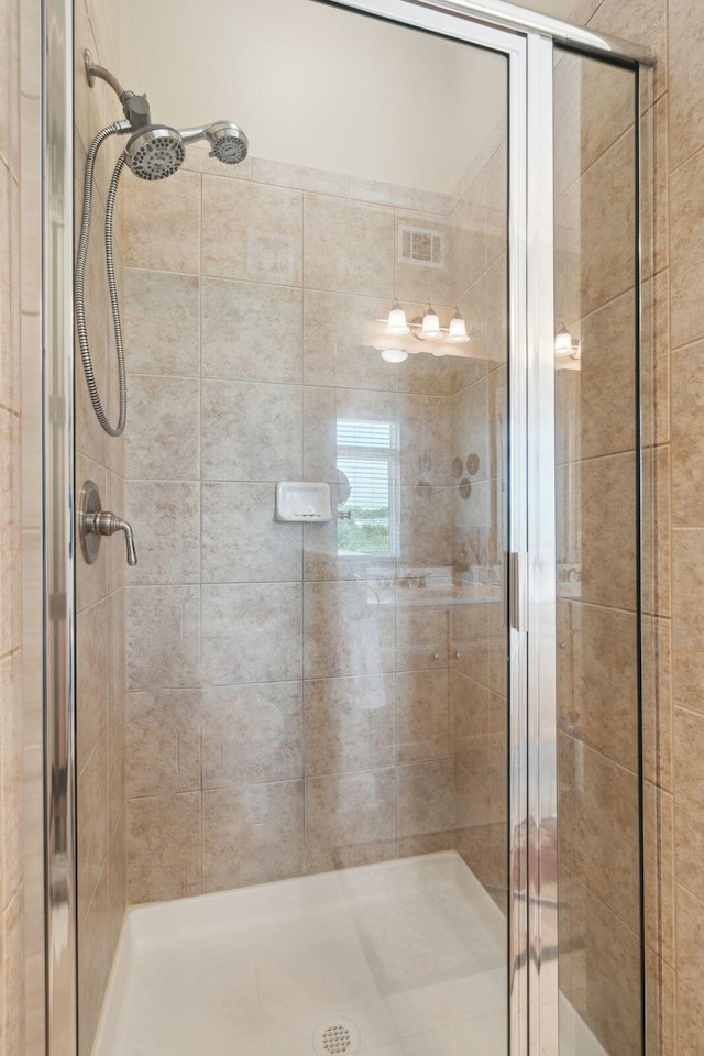 bathroom featuring a stall shower and visible vents