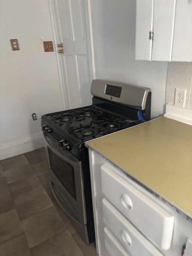 1907 Helm Ave, North Charleston, SC 29405 - kitchen featuring stainless steel gas stove, dark tile patterned flooring, white cabinets, light countertops, and baseboards