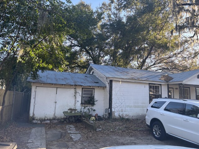 1907 Helm Ave, North Charleston, SC 29405 - view of side of home with concrete block siding, metal roof, and fence