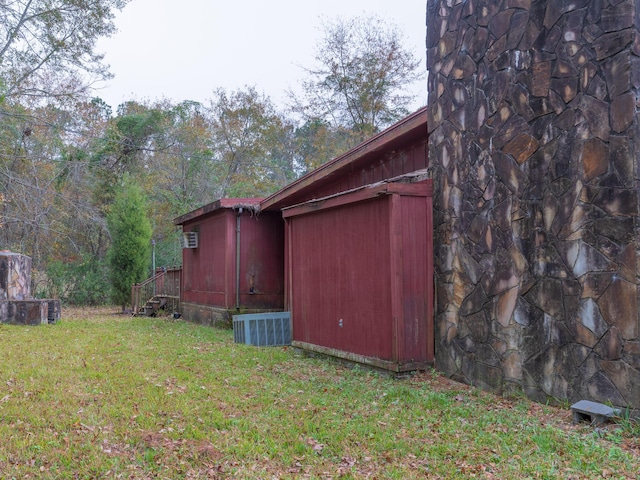 view of property exterior with a lawn and central air condition unit