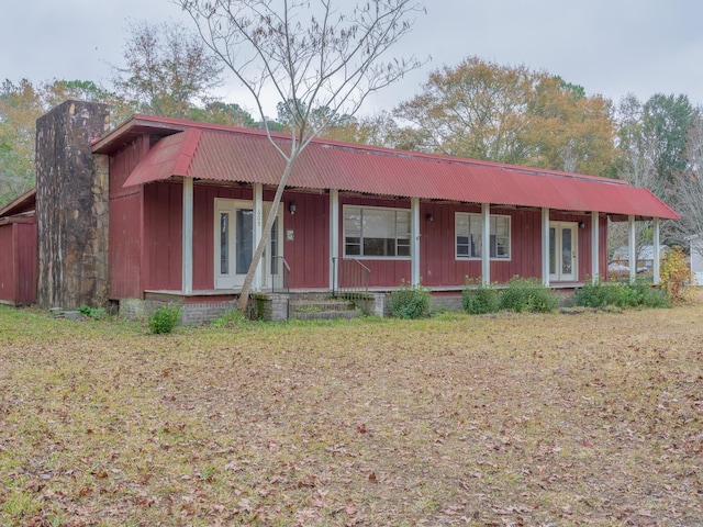 ranch-style house featuring a porch, board and batten siding, and a front yard