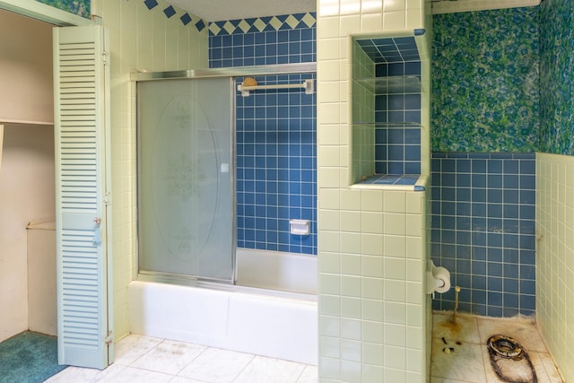 full bath with enclosed tub / shower combo, tile walls, and tile patterned floors