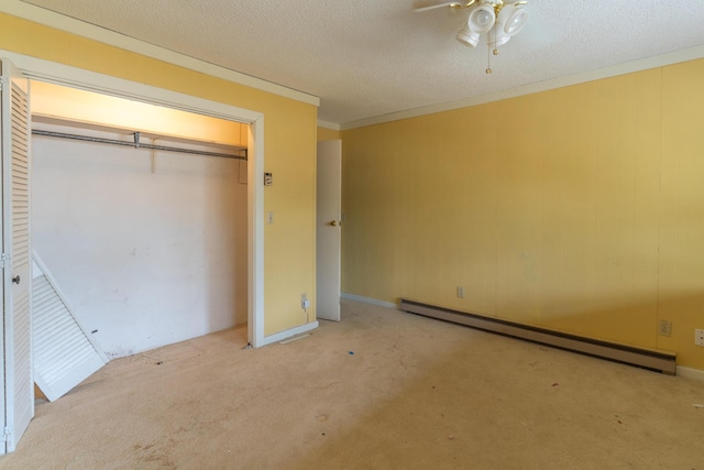 unfurnished bedroom with a closet, ornamental molding, baseboard heating, and a textured ceiling