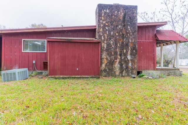 view of side of home featuring a lawn and central AC unit