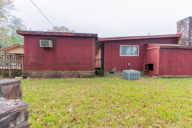 back of house with crawl space, a chimney, and a lawn