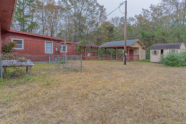 view of yard with a shed, an outdoor structure, and fence