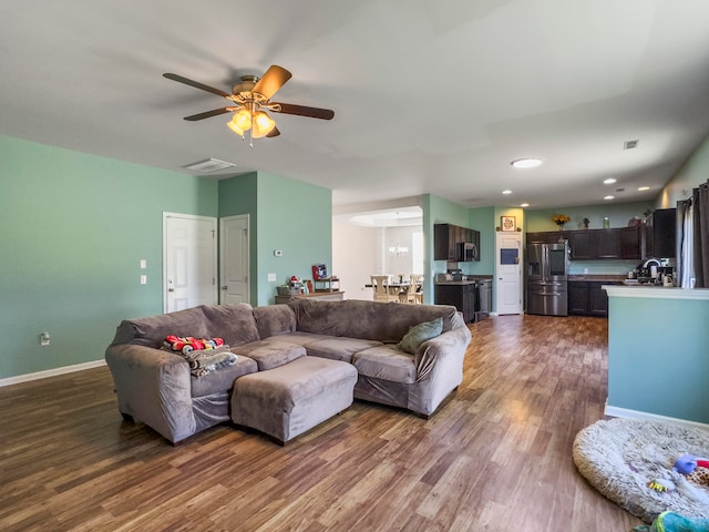 living room with ceiling fan, sink, and dark hardwood / wood-style floors