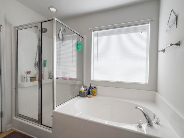 bathroom featuring independent shower and bath and a wealth of natural light