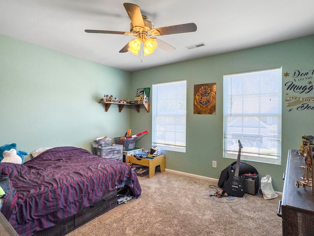 carpeted bedroom featuring multiple windows and ceiling fan