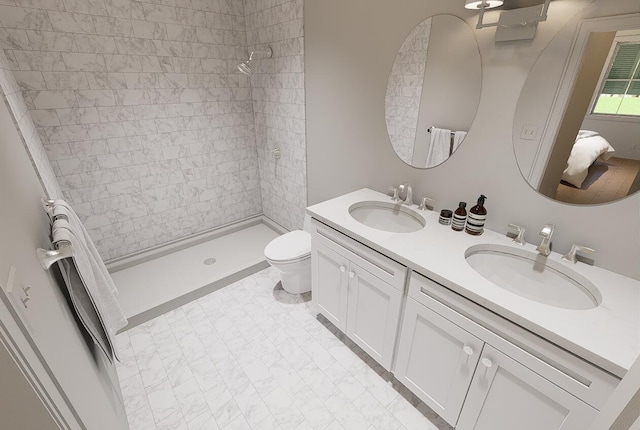 ensuite bathroom with toilet, a stall shower, double vanity, and a sink