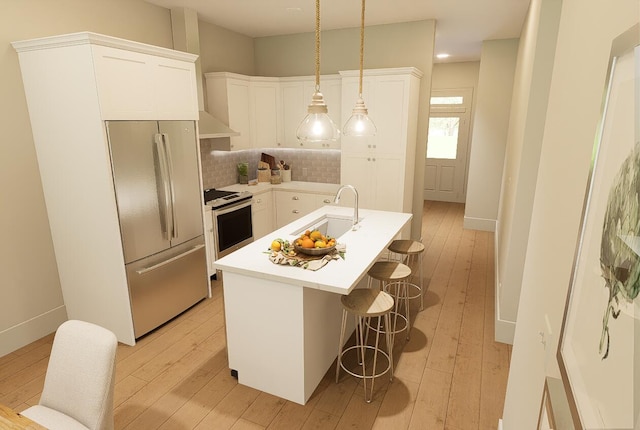kitchen featuring an island with sink, appliances with stainless steel finishes, light countertops, white cabinetry, and a sink