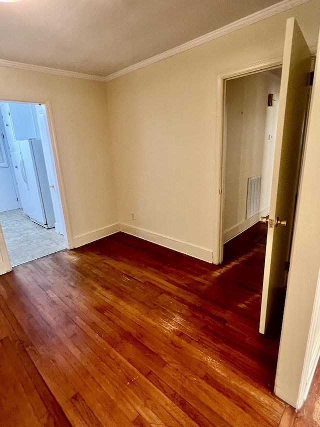 empty room with crown molding and dark wood-type flooring