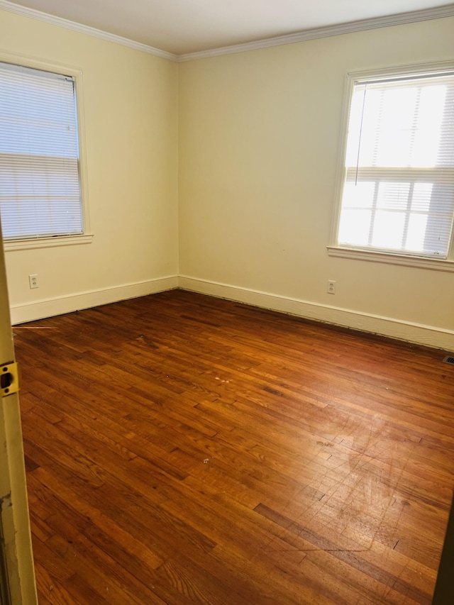 empty room featuring hardwood / wood-style flooring and ornamental molding