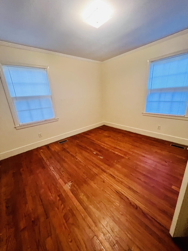 spare room featuring hardwood / wood-style flooring and ornamental molding