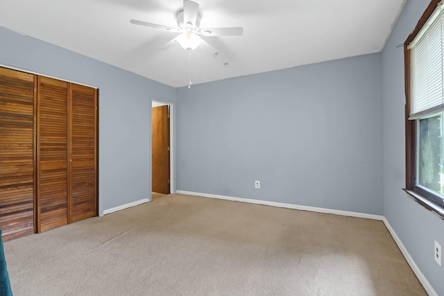 unfurnished bedroom with light carpet, ceiling fan, and a closet
