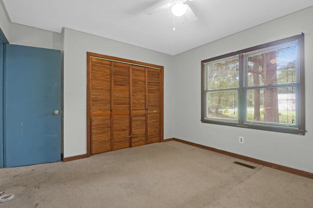 unfurnished bedroom with ceiling fan, a closet, and carpet flooring
