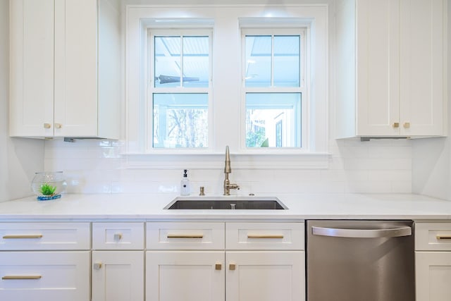 kitchen featuring a sink, white cabinetry, decorative backsplash, and stainless steel dishwasher