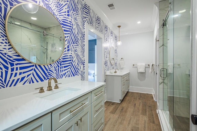 full bath with visible vents, wood finished floors, a stall shower, and a sink