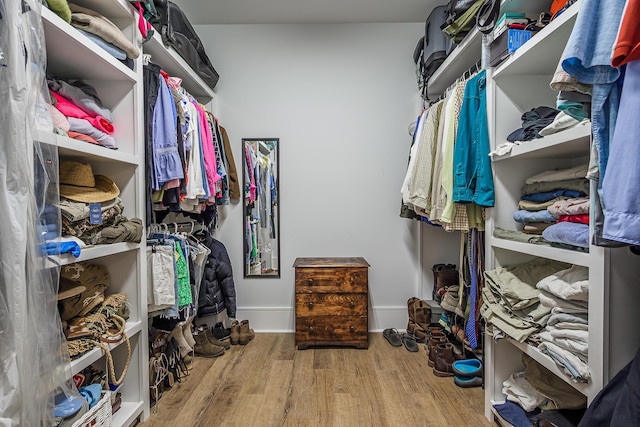 walk in closet with wood finished floors