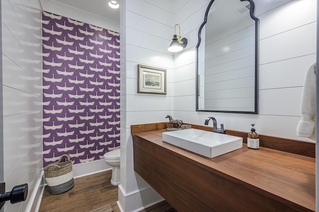 full bathroom featuring visible vents, toilet, wood finished floors, a shower with shower curtain, and vanity