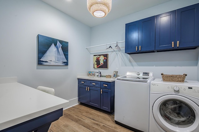 laundry area with baseboards, cabinet space, a sink, light wood-style floors, and washing machine and dryer